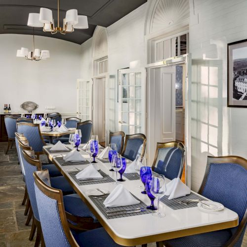 A small caf&eacute; with a long counter, row of bar stools, and chalkboard signs; warm lighting and framed pictures line the white brick walls.