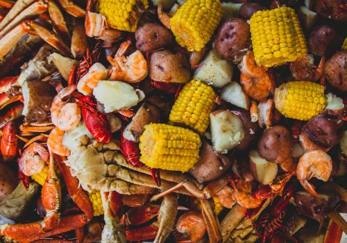 A pile of roasted seafood and veggies&mdash;shrimp, crab legs, corn on the cob, and potatoes&mdash;spread on a grill-ready platter.